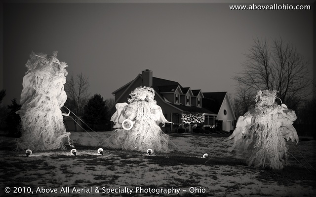 A trio of life-sized angels on display for Christmas in front of a home near Willard, Ohio; black and white conversion, vignette added