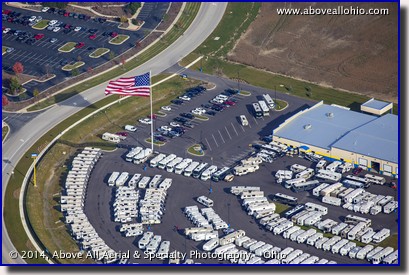 An aerial view of a huge flag waving above a local RV dealer.