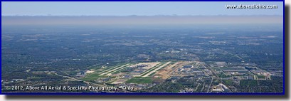 A panoramic aerial view Port Columbus International Airport ("CMH", Ohio) with a layer of solid overcast clouds in the distance.