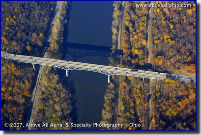 Aerial photograph of bridge over a river, train tracks, and fall trees
