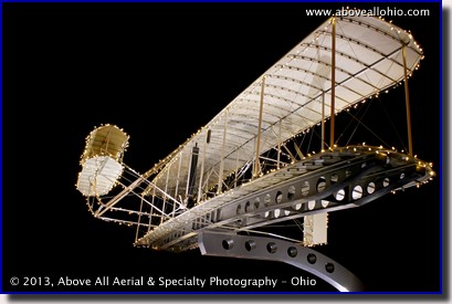 A ground-based night time architectural photo of the Wright Flyer replica at the Akron-Canton Regional Airport's Aviation Park.